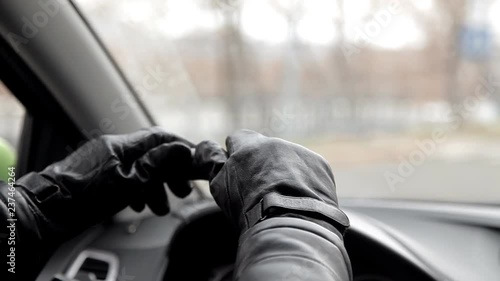 The perpetrator waits for a victim sitting in car with black gloves and a gun. Seeing the woman, the offender gets out and goes to her