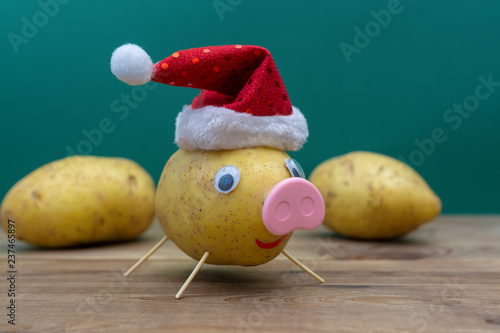 Платно pig in christmas hat made of potato. symbol of 2019