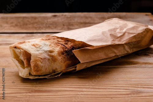 Shawarma sandwich gyro fresh roll of lavash pita bread chicken beef shawarma falafel RecipeTin Eatsfilled with grilled meat, mushrooms, cheese. Traditional Middle Eastern snack. On wooden background photo