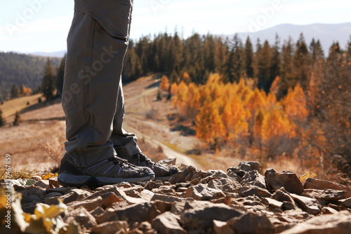 Female traveler standing on ground in mountains