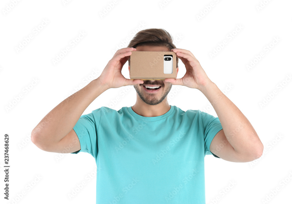 Young man using cardboard virtual reality headset, isolated on white Young man using cardboard virtual reality headset, isolated on white