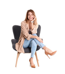 Young woman sitting in armchair on white background