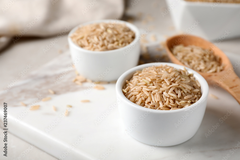 Uncooked brown rice in small bowl on table Uncooked brown rice in small bowl on table