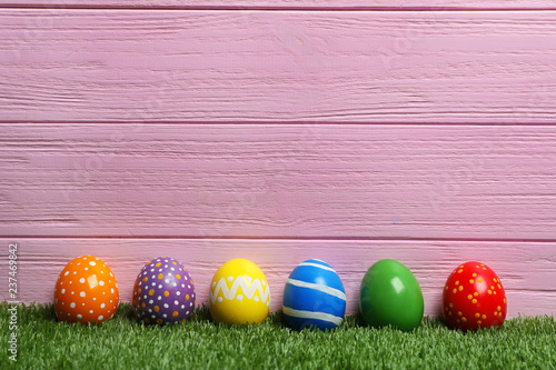 Decorated Easter eggs on green grass. Space for text