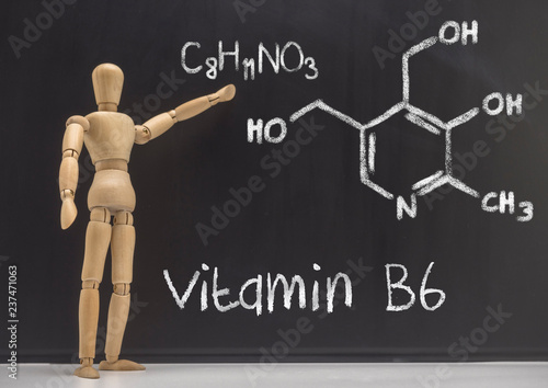 Doll articulated teaches in a blackboard the chemical composition of the vitamin B6, conceptual image