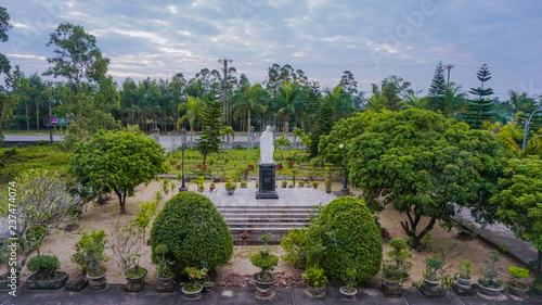 Statue of Jesus in the green garden on the territory of the Catholic Church in Mong Сai, Vietnam
