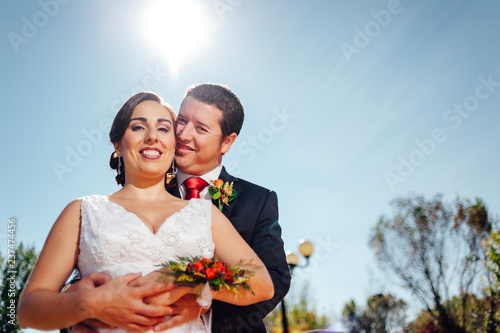 ust married couple embracing themshleves in the countryside photo