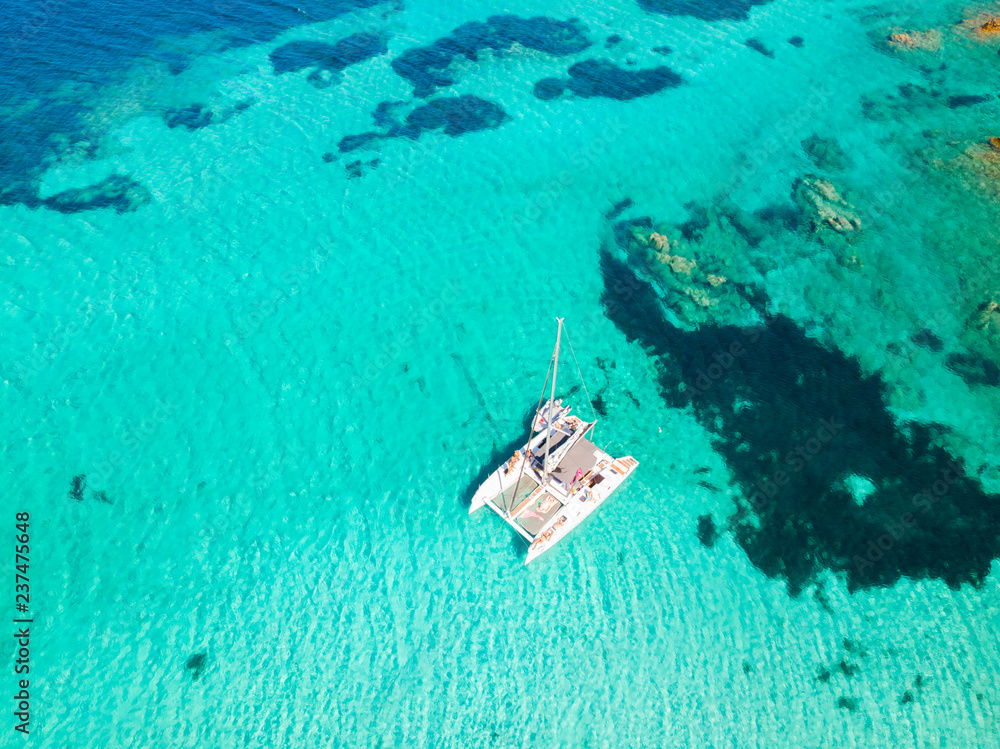 Naklejka premium Drone widok z lotu ptaka żaglówka katamaran w archipelagu Maddalena, Sardynia, Włochy. Archipelag Maddalena to grupa wysp między Korsyką a północno-wschodnią Sardynią.