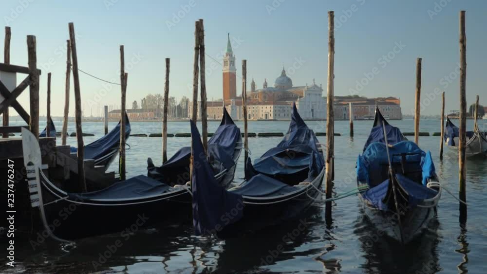 Wide slow motion shot of gondola boats in Venice Italy with a church in the distance Wide slow motion shot of gondola boats in Venice Italy with a church in the distance