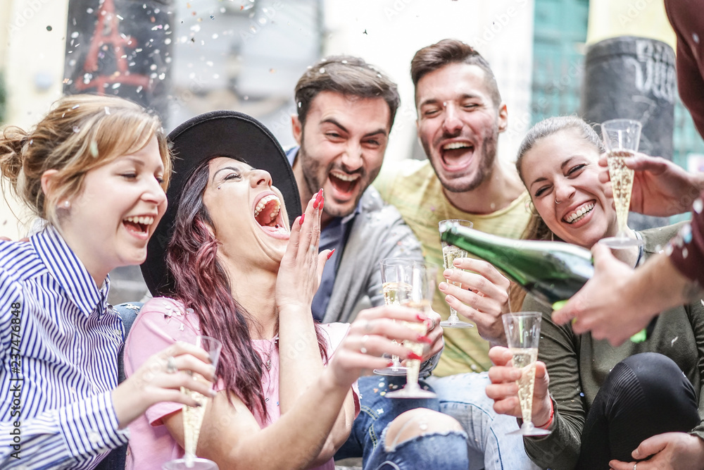Group of happy friends doing party throwing confetti and drinking champagne outdoor - Young people having fun celebrating birthday together - Friendship and youth holidays lifestyle concept