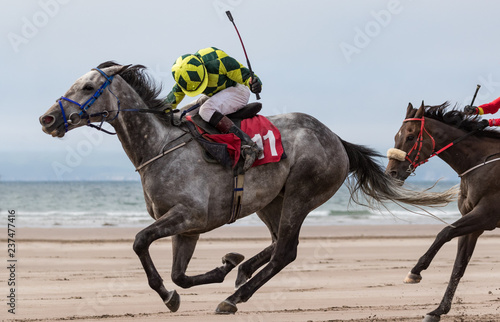 Lead race horse and jockey racing on the beach,the wild atlantic way on the west coast of Ireland