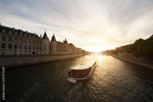 Tourist boat tour on Seine river with beautiful sunset in Paris . Cruise ship sightseeing along river in Paris, France.