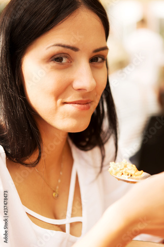 Young woman is eating in restaurant.