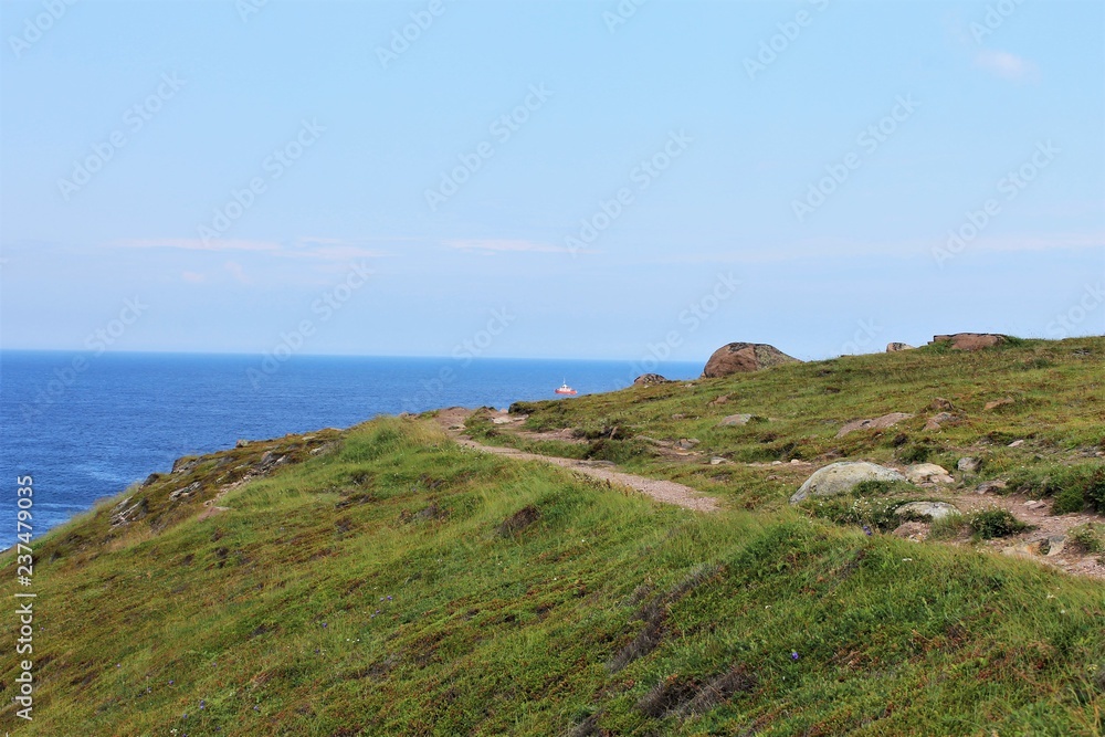 Trail along cliff's edge, Cape Spear, Newfoundland. Ship visible on the ocean in the background. Trail along cliff's edge, Cape Spear, Newfoundland. Ship visible on the ocean in the background.