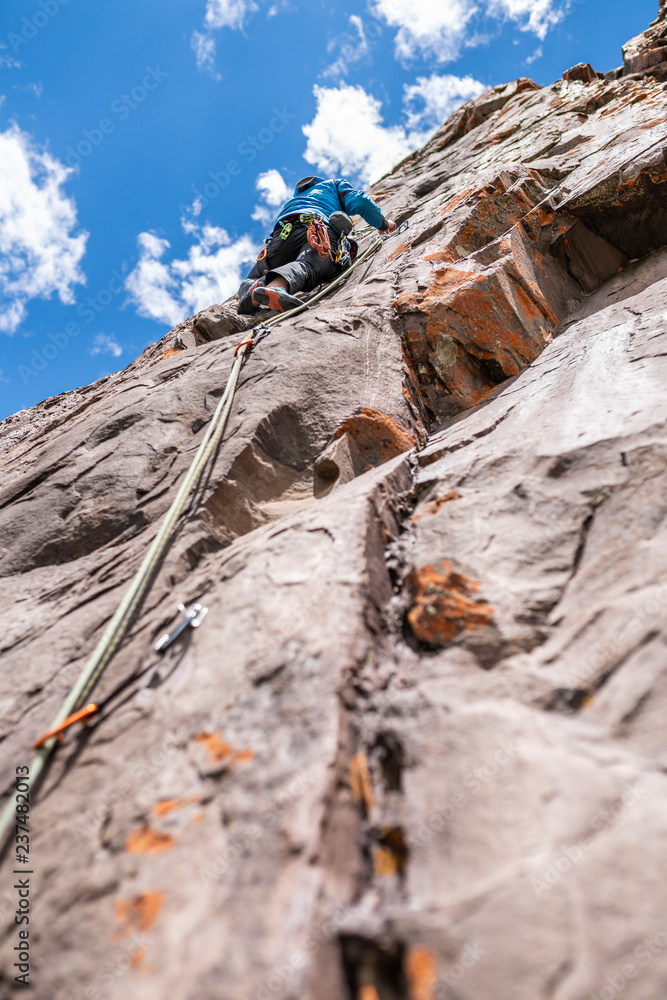 The last movements to reach the summit by a male climber. Rock climbing inside Andes mountains and valleys at Cajon del Maipo, an amazing place to enjoy rock climbing and mountaineering sports, Chile
