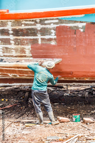 Man painting antifoul on the underside of a boat photo
