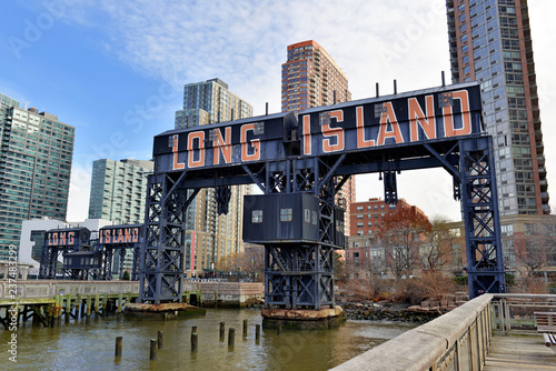 Vintage Railroad Gantries and Long Island sign with skyscrapers and apartment buildings in background, Long Island City, New York