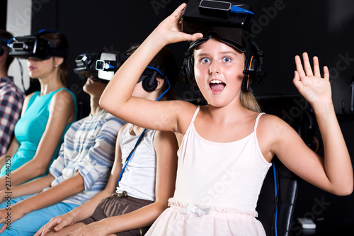 Young girl is excited by watching the video in VR glasses