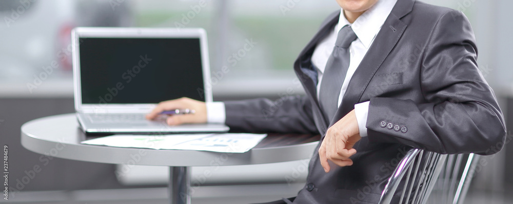 young businessman sitting at workplace and looking at camera young businessman sitting at workplace and looking at camera