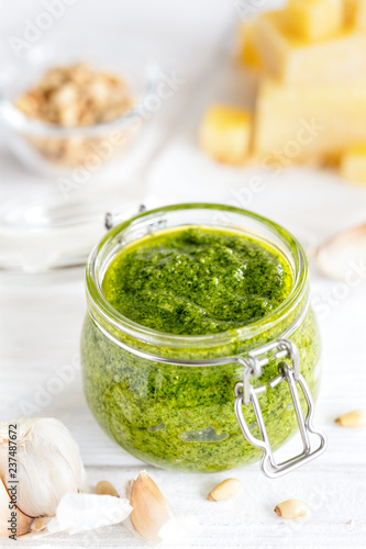 Home made Basil pesto sauce and fresh ingredient on white background, vertical composition