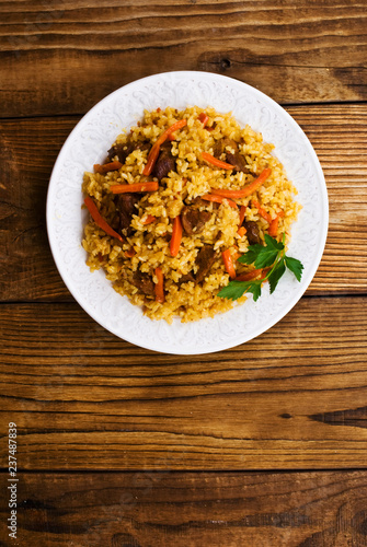 pilaf in a plate on wooden background
