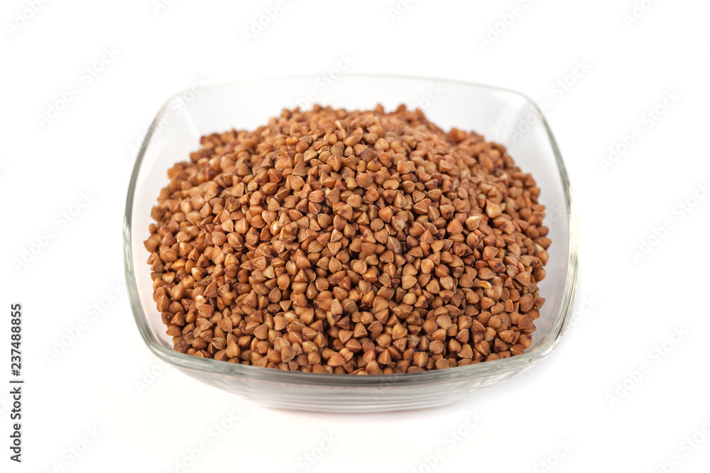 Roasted buckwheat grains in glass bowl isolated on white background Roasted buckwheat grains in glass bowl isolated on white background