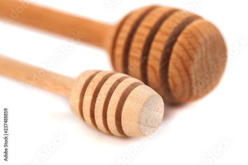 Two wooden honey dippers isolated over white background