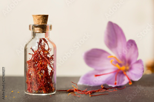 Dried saffron spice in a bottle and Saffron flower