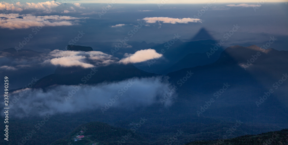 shadow of the conical mountain Adam's Peak or Sri Pada at sunrise - sacred buddhist place. Sri Lanka