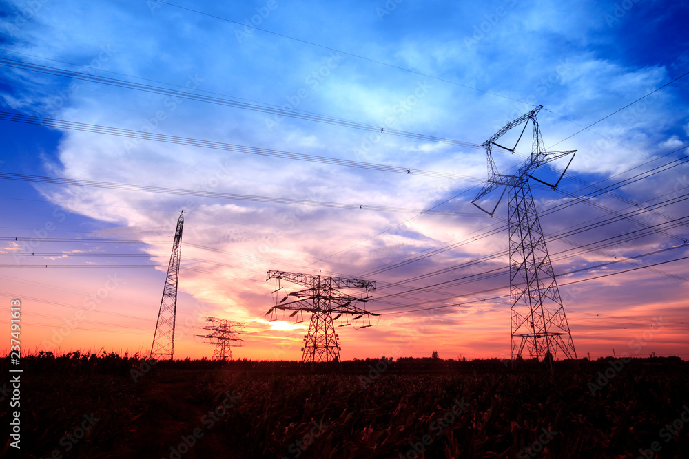 Obraz premium In the evening, the silhouette of high voltage towers
