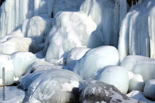 Ice blockes and walls on frozen rocks and stones, formed during freezing of lake Baikal photo