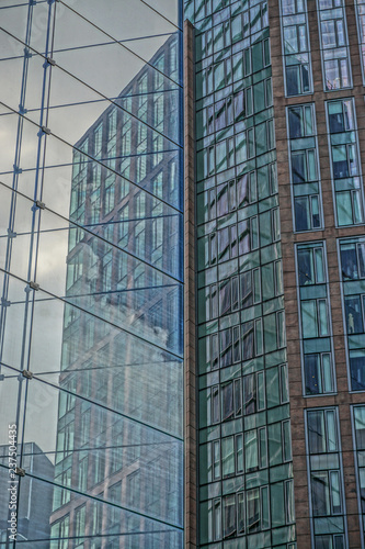 Abstract patterns formed by the reflections of buildings in the glass facade of a modern office building.