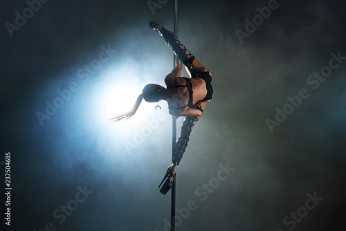 Sexy woman in a black lingerie dancing on a pylon