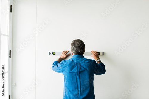 Man using a spirit level on a wall