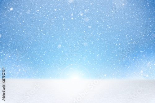 Winter image with white bright and fresh snow at bottom and falling snowflakes on blue background. Background template for your project.