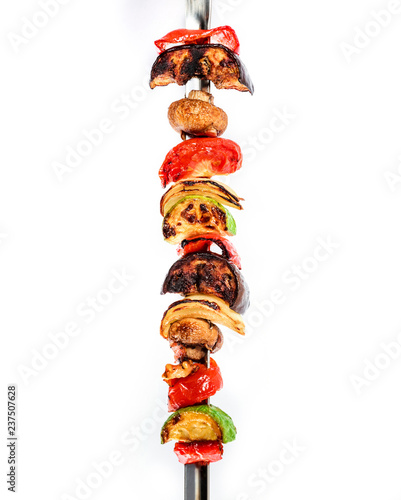 Grilled vegetable kebabs on skewers with cherry tomato, pepper, mushrooms, squash and onion on white background