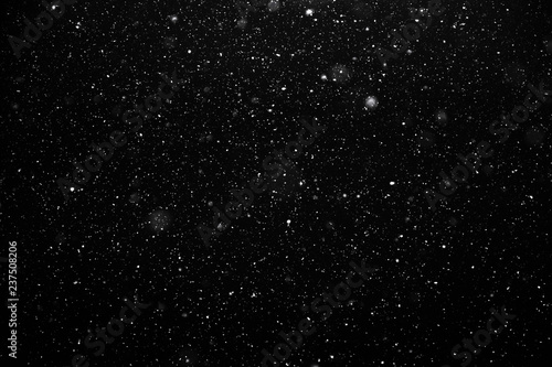Real falling snow isolated on a black background. For use as layer snow in your project.