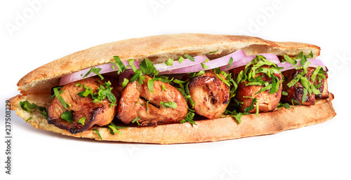 Grilled meat in sandwich with onion and greens on white background. Shashlik or Shish kebab popular in Eastern Europe. Hot meat dishes