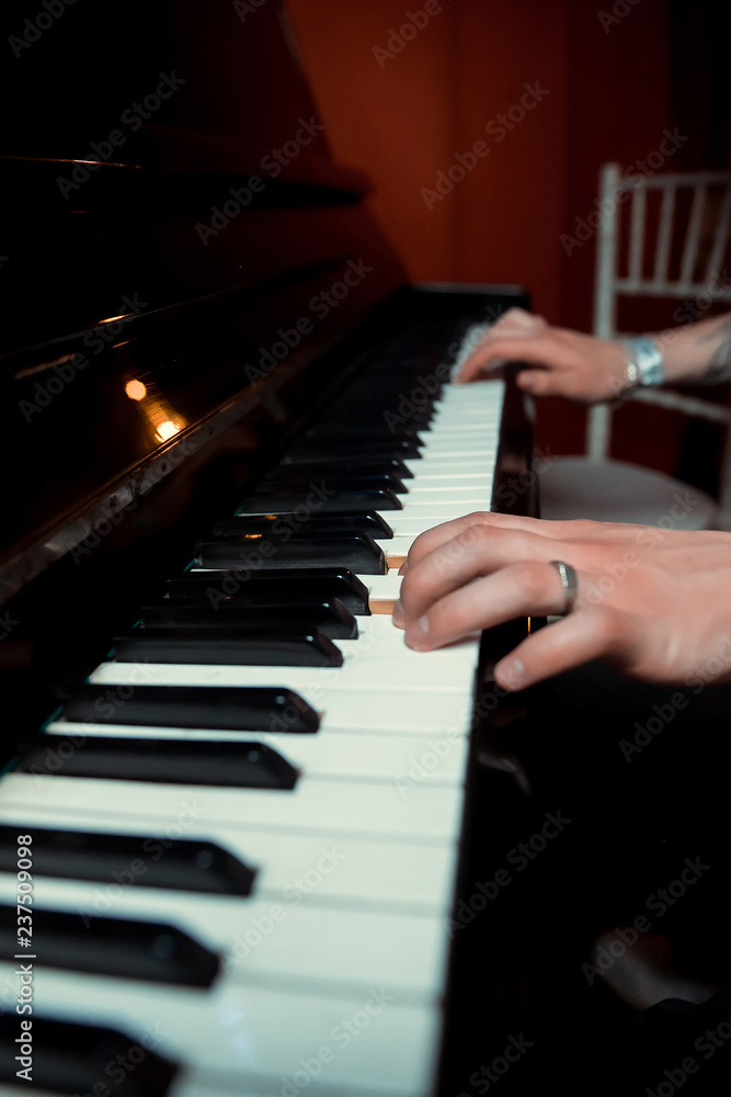 a man playing the piano at a party, bar, restaurant, pub at an event
