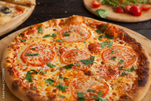 pizza, fresh tomato pizza with mozzarella and cheese. Italian pizzeria. Fresh pizza on the kitchen table