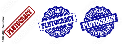 PLUTOCRACY scratched stamp seals in red and blue colors. Vector PLUTOCRACY labels with grainy style. Graphic elements are rounded rectangles, rosettes, circles and text captions.