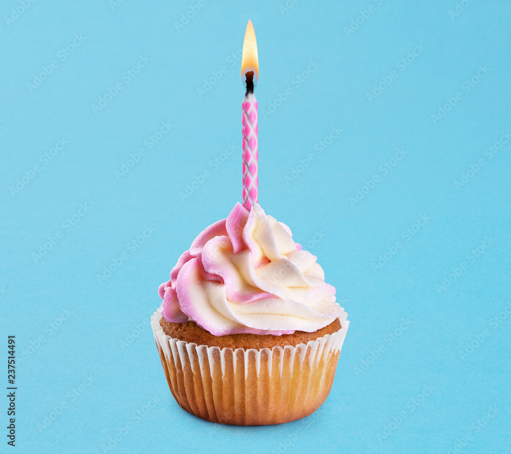 Cupcake with birthday candle on a blue background. Stock Photo | Adobe Stock