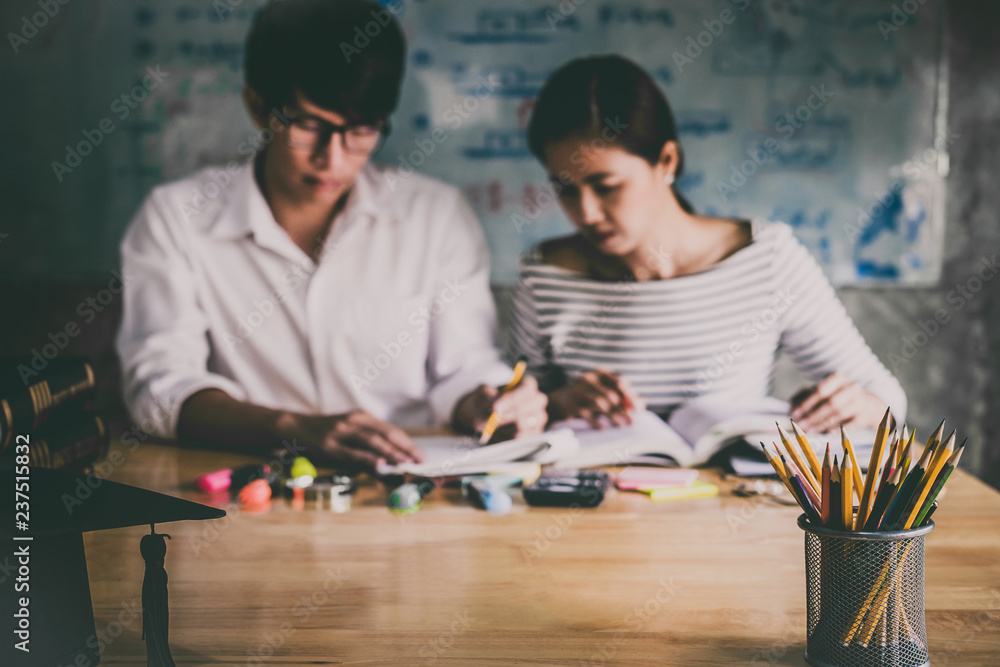 Fototapeta premium High school or college Asian student group sitting at desk in class studying and reading, doing homework and lesson practice preparing exam to entrance, education concept
