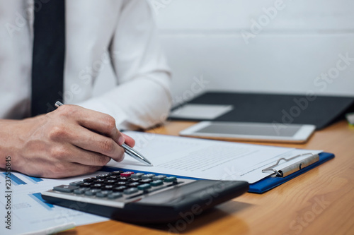 Business man or accountant working Financial investment on calculator with calculate Analyze business and market growth on financial document data graph