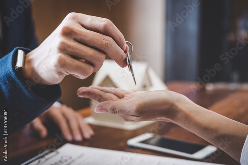 Real estate agent Sales manager holding filing keys to customer after signing rental lease contract of sale purchase agreement, concerning mortgage loan offer for and house insurance