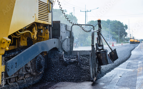 Close-up of asphalt pavers working on supplement of asphalt site, road construction photo