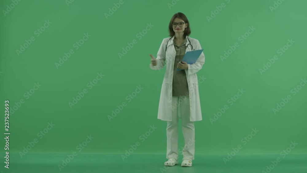 the doctor pointы at something on green screen and shows thumb on the green screen the doctor pointы at something on green screen and shows thumb on the green screen