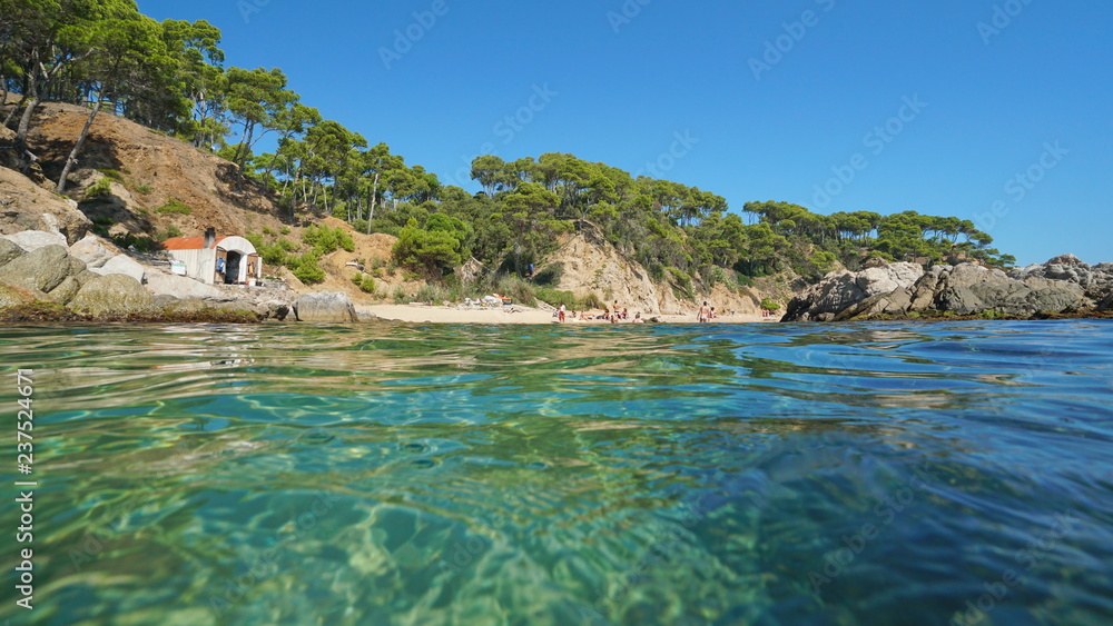 Spain Costa Brava beach with a fisherman hut near Palamos seen from water surface, Cala Estreta, Mediterranean sea, Catalonia