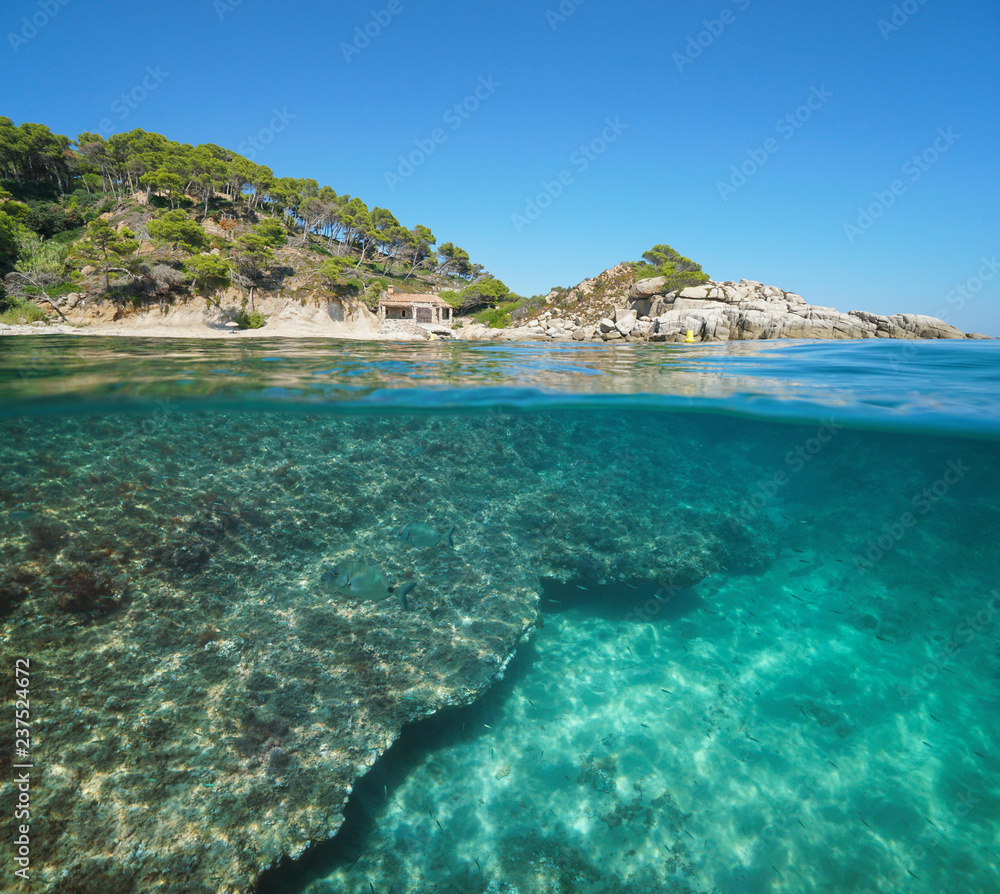 Spain Costa Brava coastline with a fisherman hut and fish with rock underwater, split view half above and below water surface, Mediterranean sea, Cala Cap de Planes, Palamos