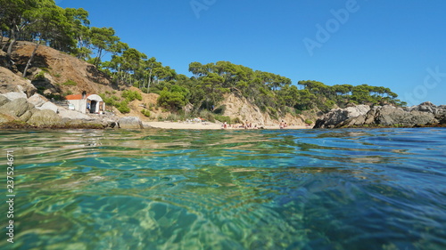Spain Costa Brava beach with a fisherman hut near Palamos seen from water surface, Cala Estreta, Mediterranean sea, Catalonia © dam